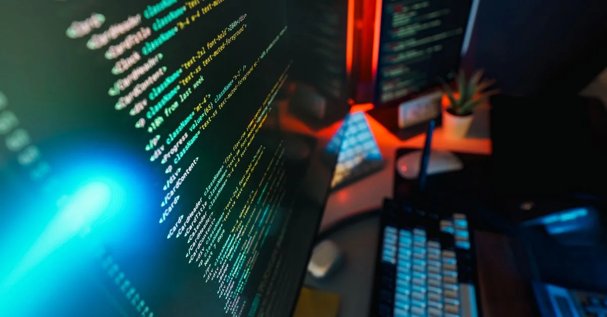 Espace de travail futuriste doté d'un écran d'ordinateur lumineux avec codage affiché, idéal pour les concepts technologiques et de programmation.