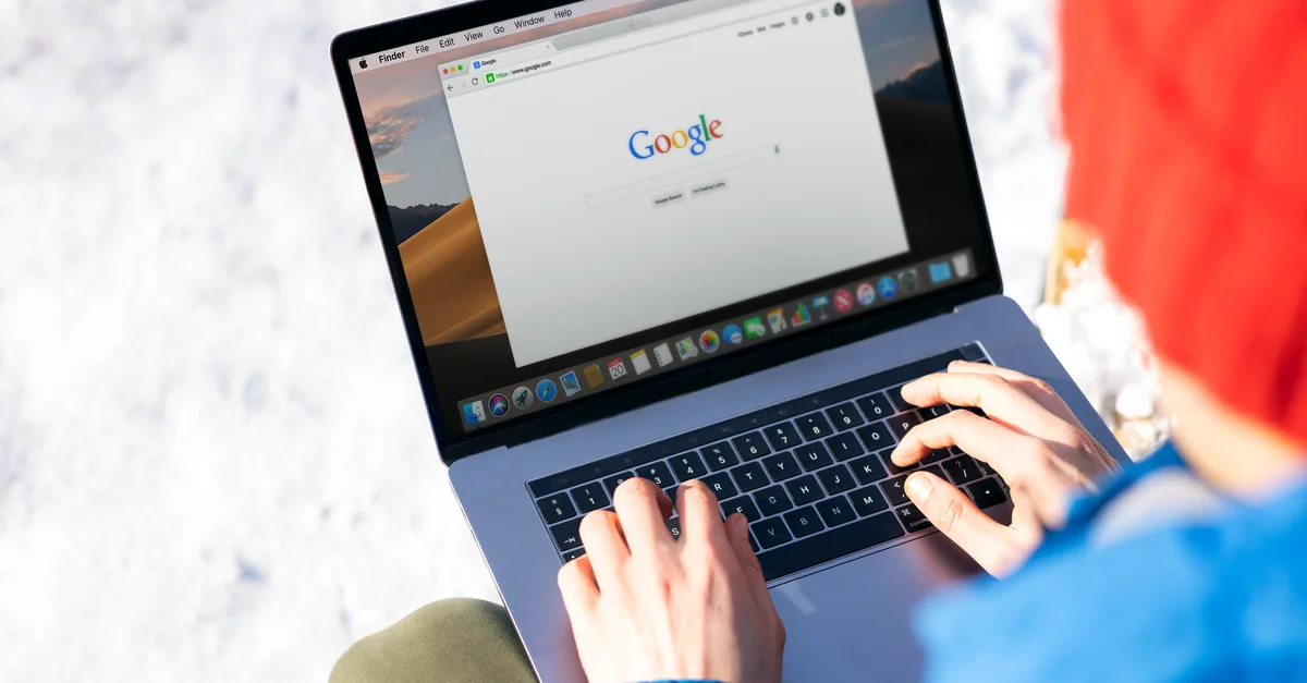 Personne tapant sur un ordinateur portable en extérieur avec de la neige, accédant à Internet.