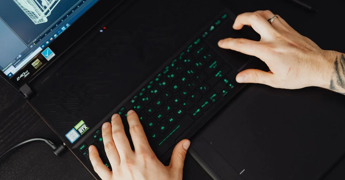 Mains tapant sur un clavier d'ordinateur portable, idéal pour des thèmes technologiques et de travail.